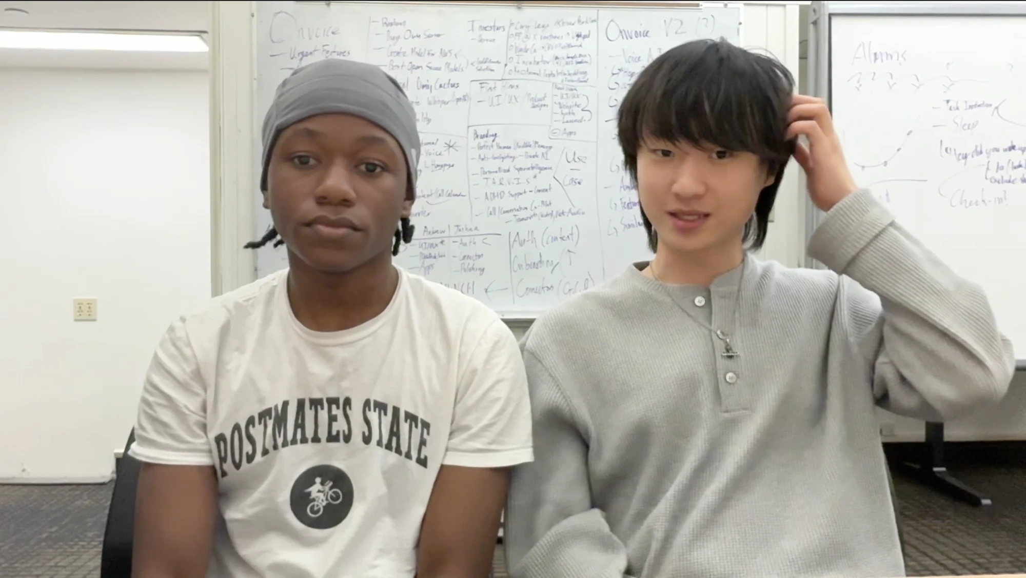 Andrew and Joshua in front of a whiteboard covered in Onvoice plans