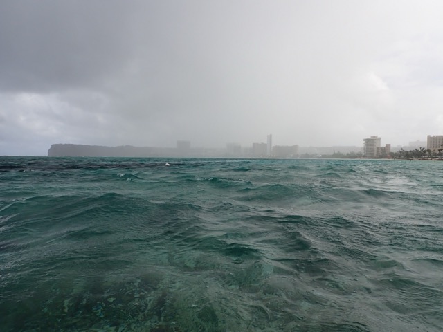 Choppy, stormy water across Tumon Bay under heavy rain clouds